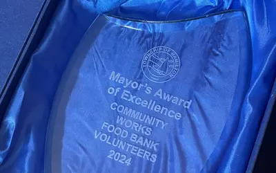 a glass award engraved with the Mayor's Award of Excellence