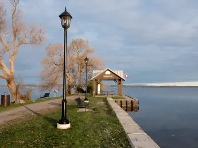 Harwood Waterfront Park focused on a lamp-lined path leading to a gazebo surrounded by greenery and rice lake