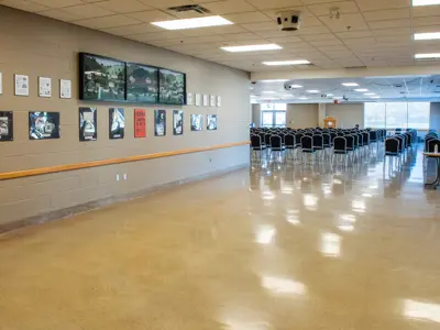 empty banquet hall with chairs arranged in theatre style rows facing a podium and framed pictures of historical properties