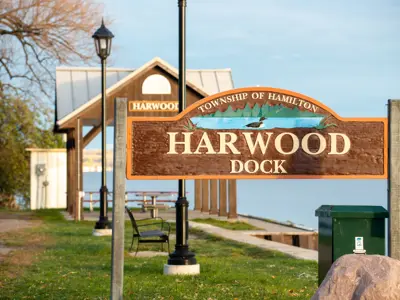 Harwood Dock sign with the Harwood waterfront park gazebo and lake visible in the background