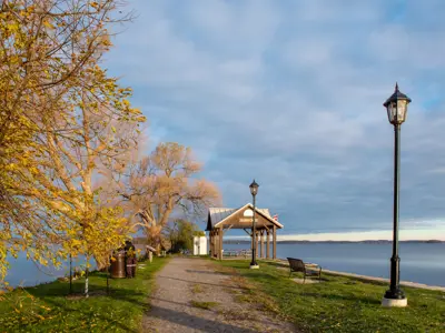 Harwood Waterfront Park focused on a lamp-lined path leading to a gazebo surrounded by greenery and rice lake