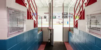 Baltimore arena ice rink from the entrance between bleachers with rules and regulations notices visible