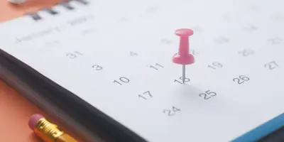 a pushpin on a date of a calendar