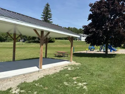 Cold Springs Park focused on a picnic shelter with picnic tables and the playground visible in the background
