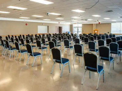 empty banquet hall with chairs arranged in theatre style rows facing a podium