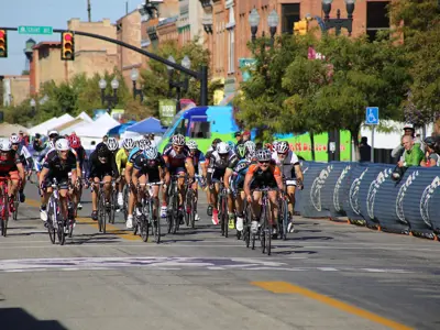 bike race with many contestants moving through a barrier lined street