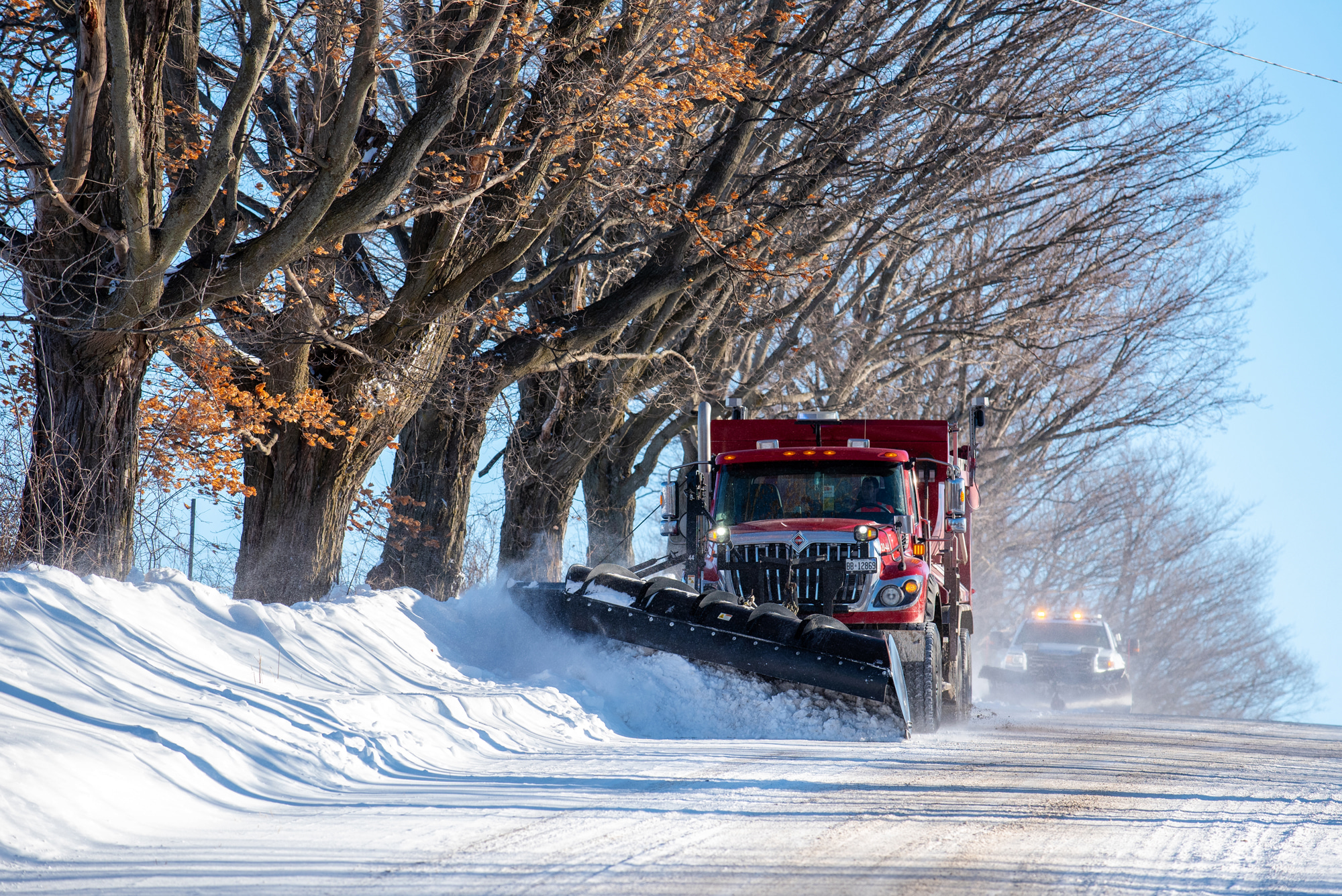 snowplow pushing snow to the side of the roads