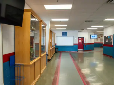 Empty Baltimore arena hallway lined with trophy cases, ending with a closed canteen window