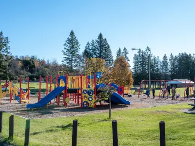 Baltimore arena playground from afar with children playing on swings and climbing structures