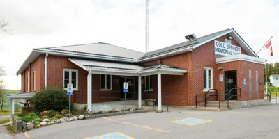 Exterior of Cold Springs Memorial Hall featuring accessible parking spaces and greenery